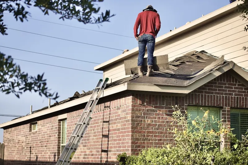 Professional roofer working on a residential roof in Greenwood Hills